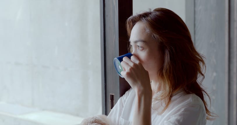 woman at window drinking tea